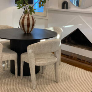 Customer dining area with a black round table and boucle chairs