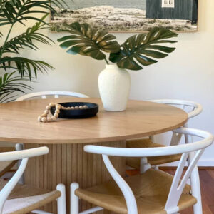 Customer dining nook with a round timber table and white wishbone chairs