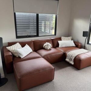 Customer living room with a tan leather modular sofa and ottoman